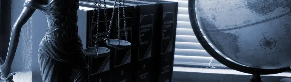 Photographie avec une figurine allégorique de la Justice, des ouvrages et une mappemonde